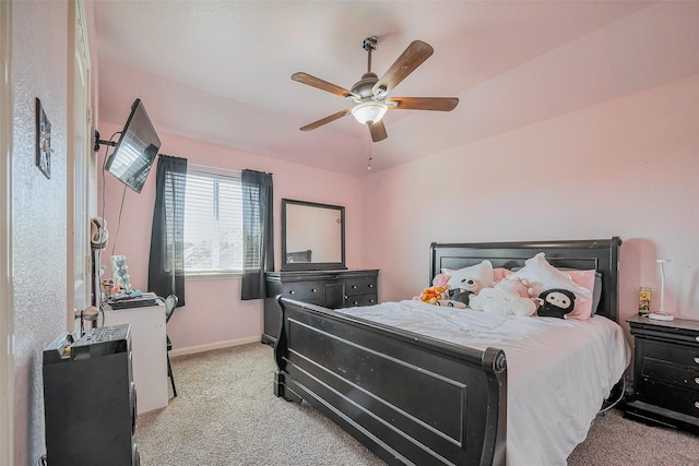 bedroom featuring a ceiling fan, light colored carpet, and baseboards