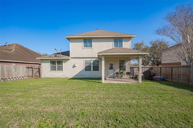 back of property with a yard, a patio, and a fenced backyard