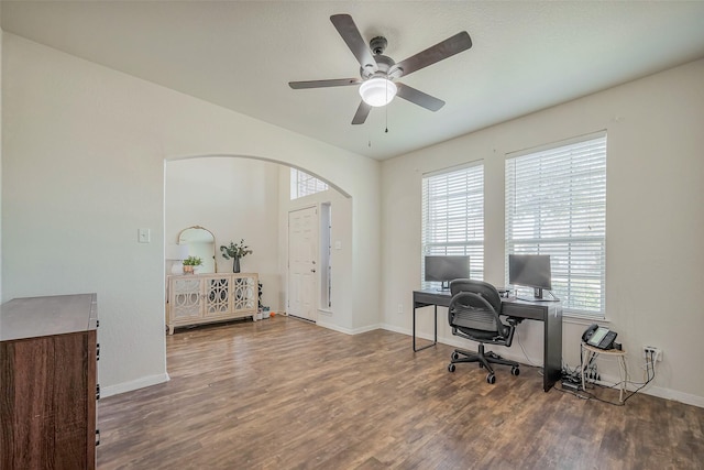 office featuring arched walkways, baseboards, and wood finished floors