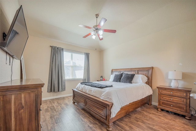 bedroom with a ceiling fan, lofted ceiling, baseboards, and wood finished floors