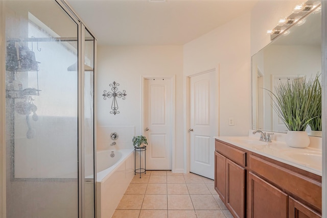 bathroom featuring a shower stall, a garden tub, double vanity, tile patterned floors, and a sink