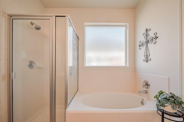 bathroom with a shower stall and a bath