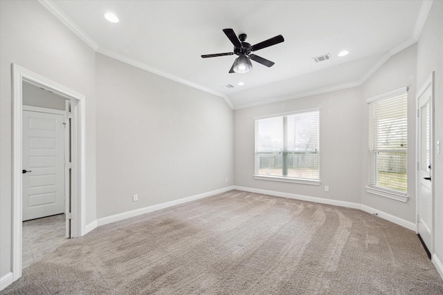 spare room with crown molding, light colored carpet, ceiling fan, and vaulted ceiling