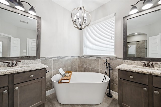 bathroom with vanity, shower with separate bathtub, a chandelier, and tile walls