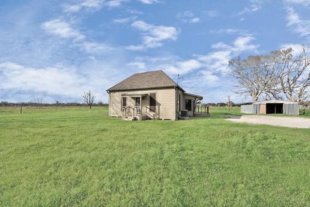 exterior space with a rural view, a yard, and an outdoor structure