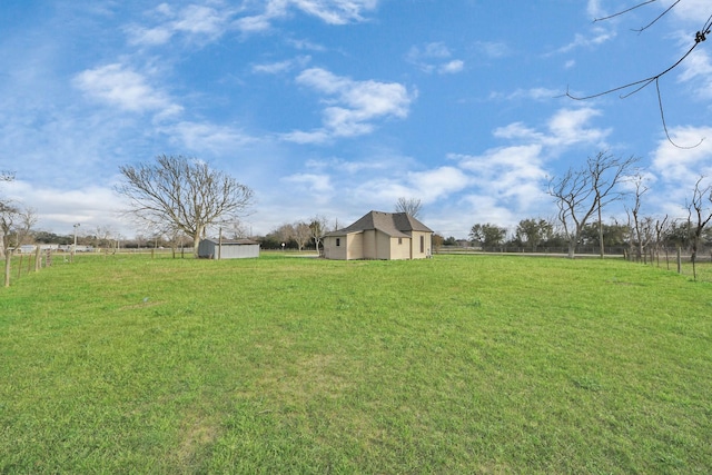 view of yard with a storage shed and a rural view