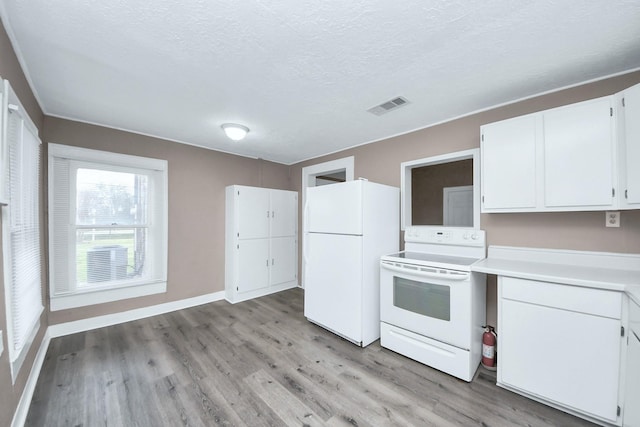 kitchen featuring white appliances, light hardwood / wood-style floors, white cabinets, and a textured ceiling