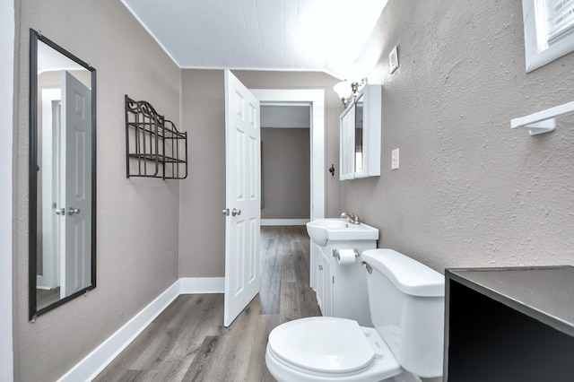 bathroom featuring vanity, wood-type flooring, and toilet