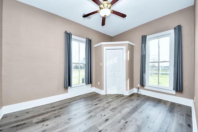 unfurnished room with ceiling fan, plenty of natural light, and hardwood / wood-style floors