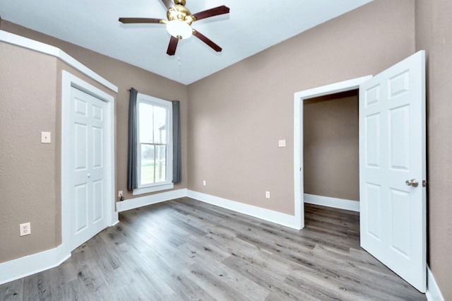 unfurnished bedroom with hardwood / wood-style floors, ceiling fan, and a closet