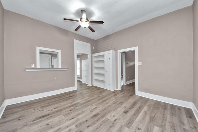 interior space with a textured ceiling, ceiling fan, and light hardwood / wood-style flooring