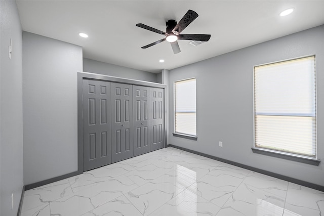 unfurnished bedroom with ceiling fan and a closet