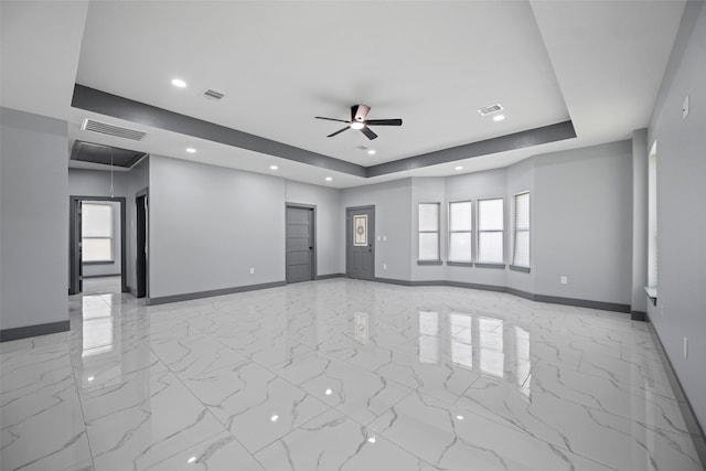 spare room featuring ceiling fan and a tray ceiling