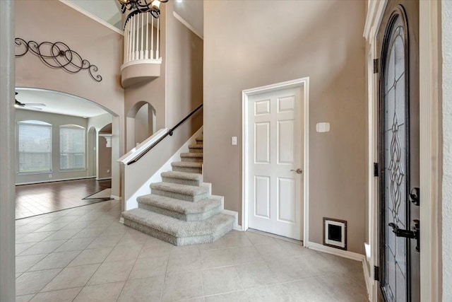 foyer entrance with a towering ceiling and light tile patterned floors