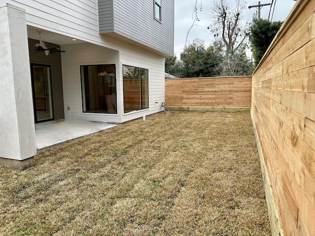 view of yard with ceiling fan and a patio