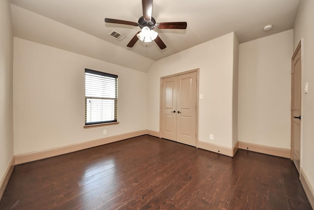 unfurnished bedroom featuring lofted ceiling, a closet, dark hardwood / wood-style floors, and ceiling fan