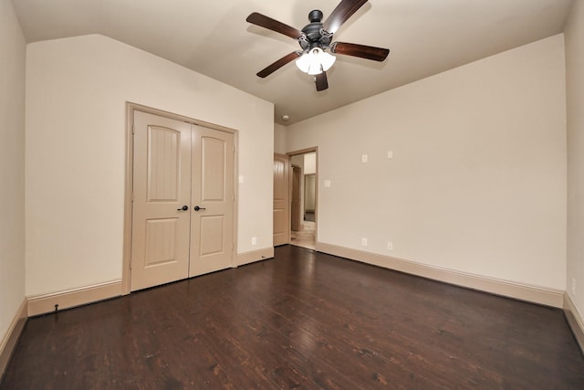 unfurnished bedroom featuring dark hardwood / wood-style flooring, lofted ceiling, a closet, and ceiling fan