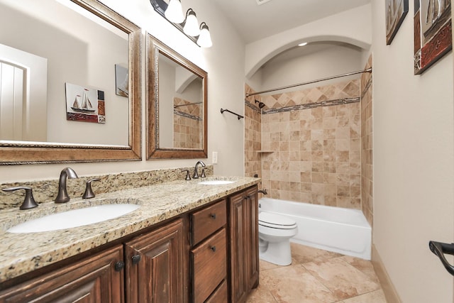 full bathroom featuring tiled shower / bath, vanity, tile patterned floors, and toilet