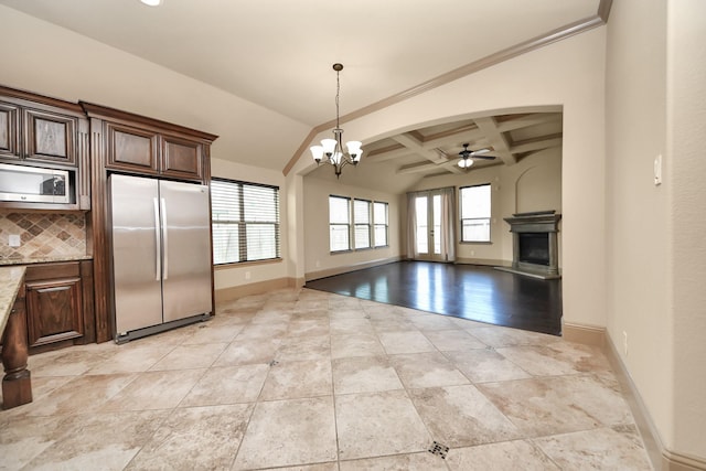 kitchen with backsplash, coffered ceiling, stainless steel appliances, light stone countertops, and dark brown cabinets