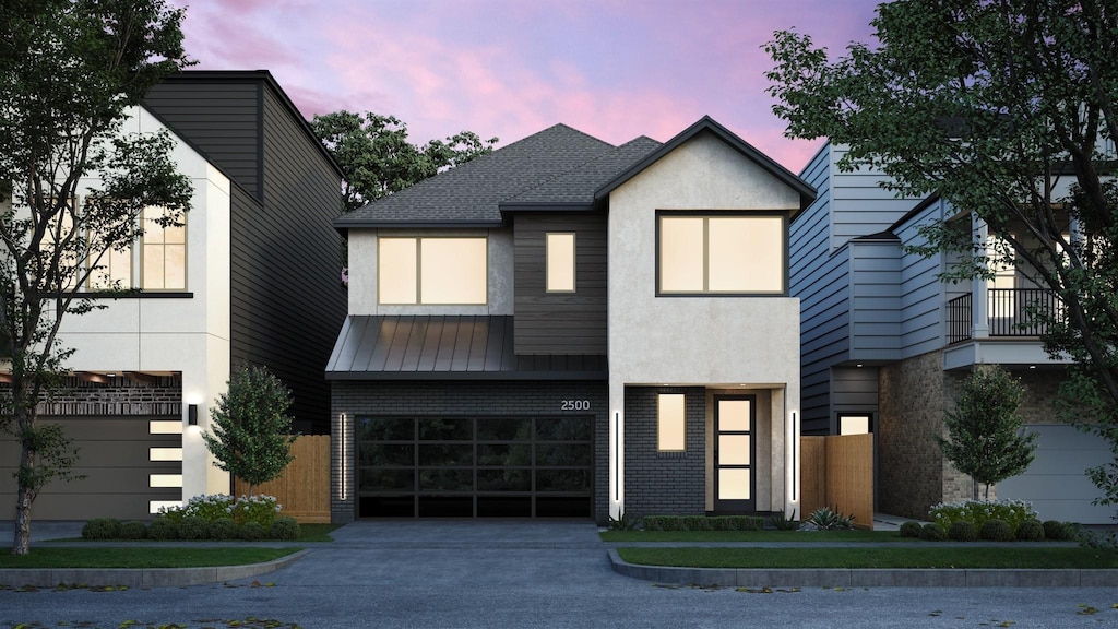 view of front facade with brick siding, driveway, an attached garage, and stucco siding