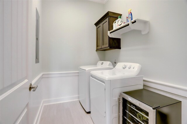 clothes washing area with cabinets and washer and clothes dryer