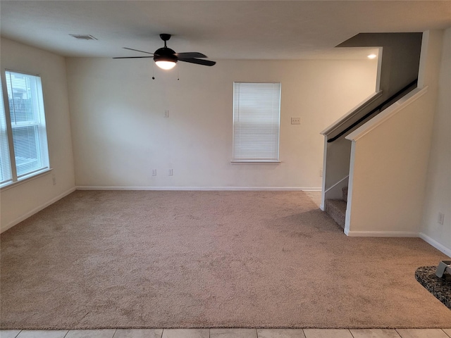 unfurnished living room with light colored carpet and ceiling fan