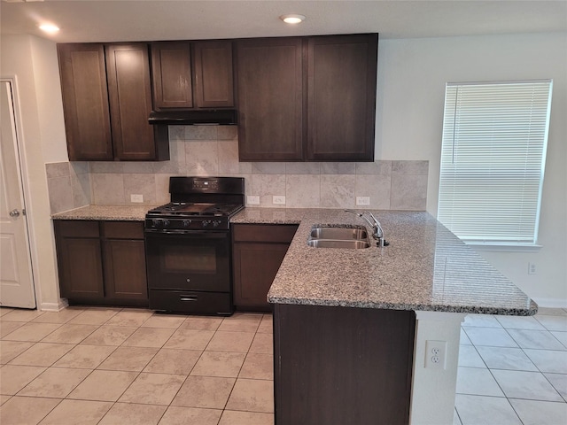 kitchen with black range with gas cooktop, sink, light stone counters, and kitchen peninsula