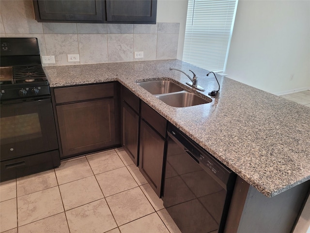 kitchen with sink, kitchen peninsula, light stone counters, and black appliances