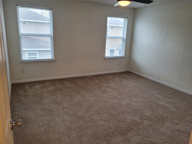 carpeted spare room featuring ceiling fan