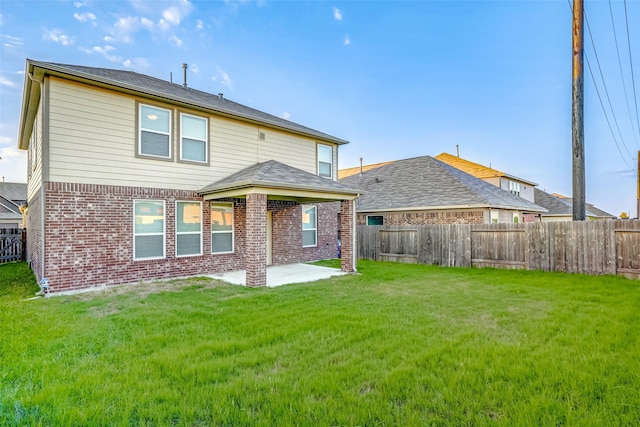 rear view of property featuring a yard and a patio area