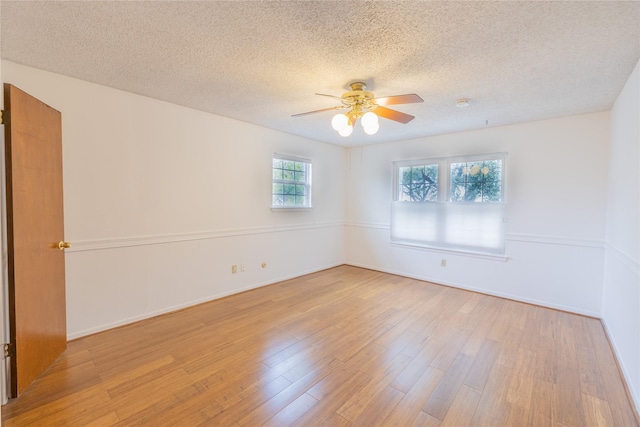 unfurnished room with ceiling fan, light hardwood / wood-style floors, and a textured ceiling