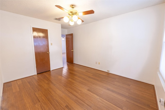 unfurnished bedroom featuring ceiling fan, hardwood / wood-style floors, and a textured ceiling