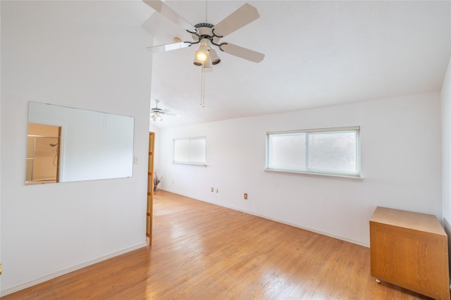 empty room featuring ceiling fan, lofted ceiling, and light wood-type flooring