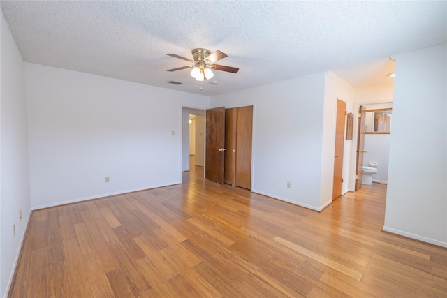 unfurnished room with ceiling fan, light hardwood / wood-style flooring, and a textured ceiling