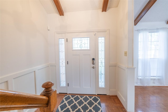 entryway featuring parquet flooring and beamed ceiling