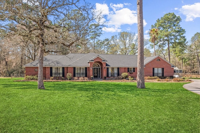 ranch-style house with a front yard and brick siding