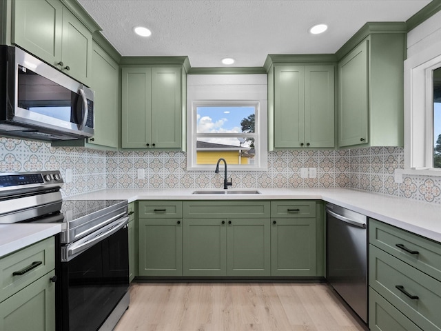 106 Palm Dr Unit Cr776, Liverpool, TX 77577 - kitchen featuring green cabinetry, appliances with stainless steel finishes, a sink, light countertops, and decorative backsplash