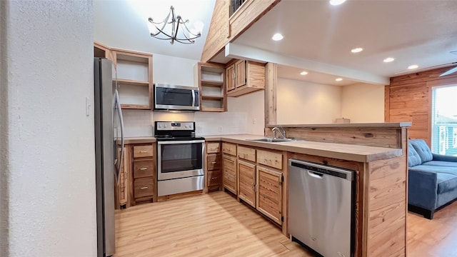 3520 Ave S Unit 1/2, Galveston, TX 77550 - kitchen featuring sink, hanging light fixtures, kitchen peninsula, stainless steel appliances, and light hardwood / wood-style flooring