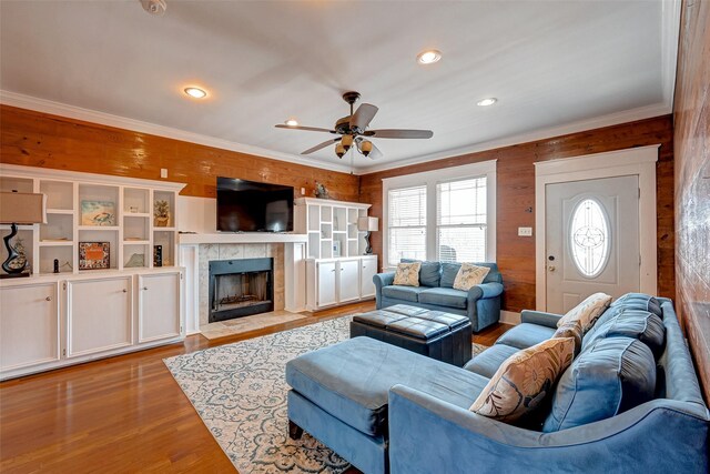 3520 Ave S Unit 1/2, Galveston, TX 77550 - living room with wood walls, light hardwood / wood-style flooring, ornamental molding, ceiling fan, and a fireplace