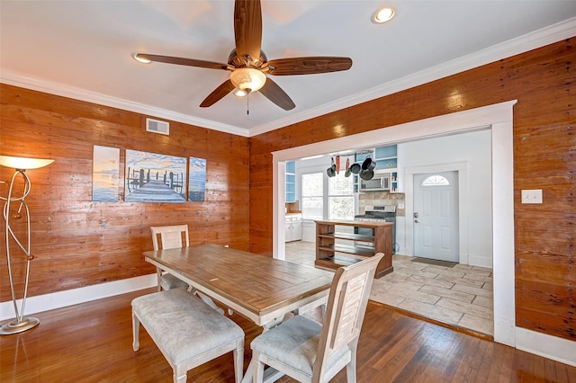 3520 Ave S Unit 1/2, Galveston, TX 77550 - dining area featuring ornamental molding, wood-type flooring, ceiling fan, and wood walls