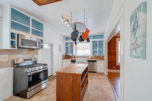 3520 Ave S Unit 1/2, Galveston, TX 77550 - kitchen featuring backsplash, stainless steel appliances, sink, and white cabinets
