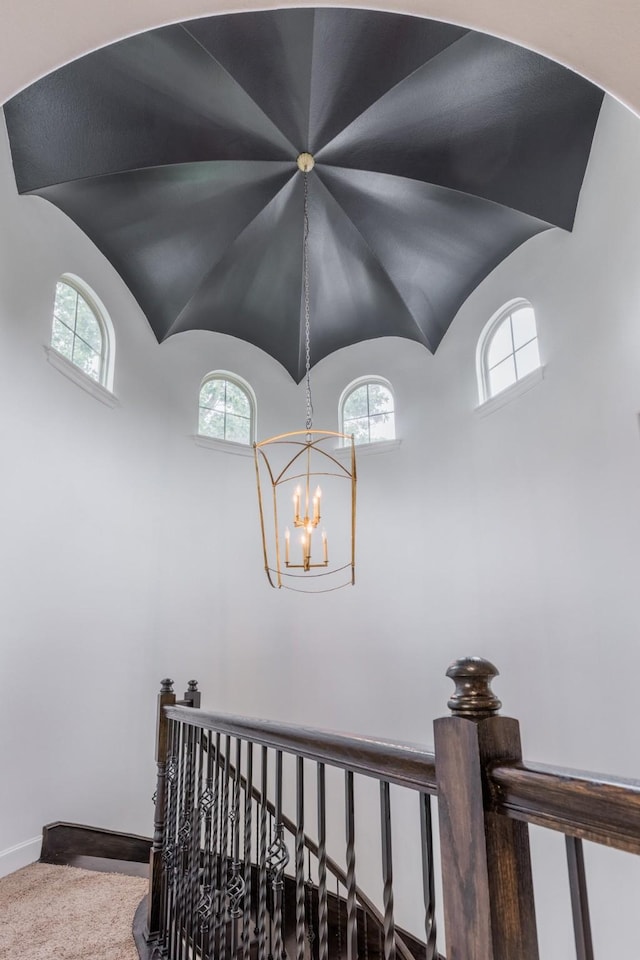 stairs featuring lofted ceiling, plenty of natural light, and baseboards