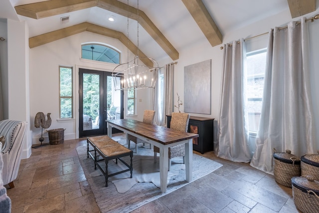 entrance foyer with visible vents, high vaulted ceiling, stone tile flooring, baseboards, and a chandelier