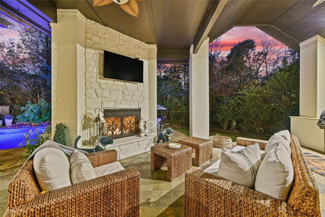 view of patio with an outdoor living space with a fireplace