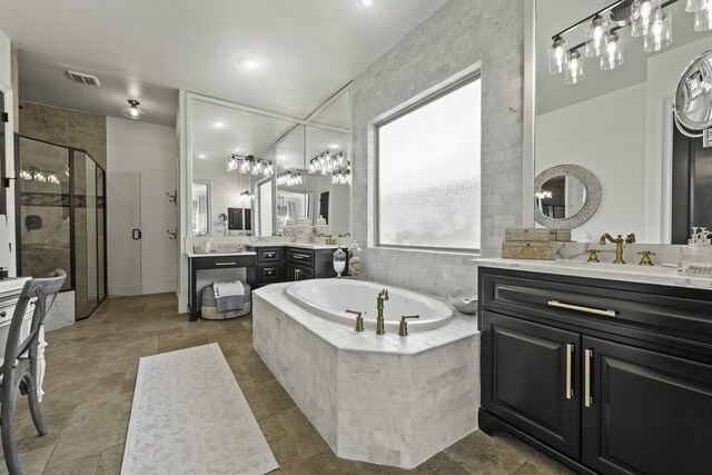 full bathroom featuring visible vents, two vanities, a sink, a shower stall, and a bath