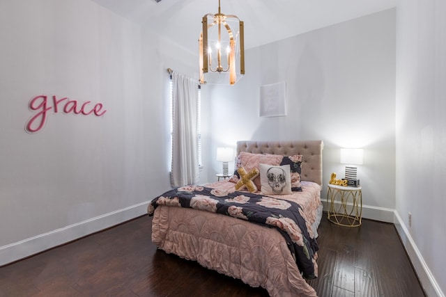 bedroom featuring baseboards, wood-type flooring, and an inviting chandelier