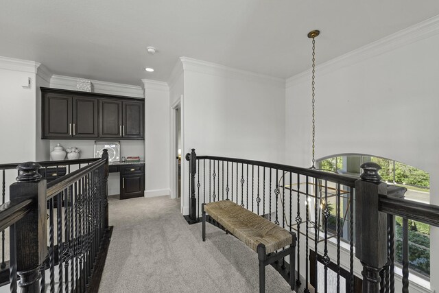 corridor featuring an upstairs landing, light colored carpet, baseboards, and ornamental molding