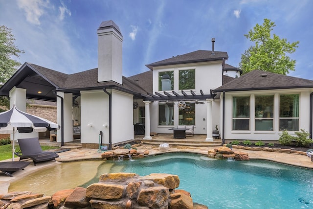 rear view of property with a patio area, a pergola, roof with shingles, and a chimney