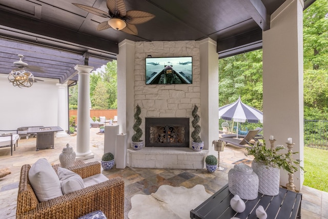 view of patio with an outdoor stone fireplace, ceiling fan, outdoor dining space, and fence