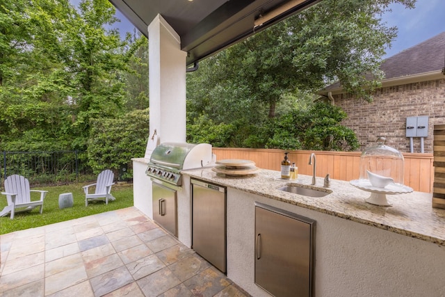 view of patio / terrace featuring a sink, area for grilling, an outdoor kitchen, and fence